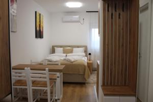 a bedroom with a bed and a table and chairs at Apartmani Fontana Banja Koviljaca in Banja Koviljača
