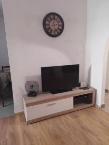 a living room with a tv and a clock on the wall at Dominik in Bar