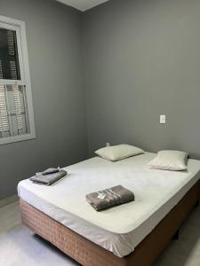 a large white bed with two pillows on it at Museu Plaza Hotel in São Paulo