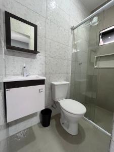 a bathroom with a toilet and a glass shower at Museu Plaza Hotel in São Paulo