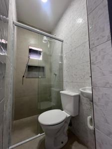 a bathroom with a toilet and a glass shower at Museu Plaza Hotel in São Paulo