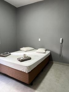 a bedroom with a bed with white sheets and a lamp at Museu Plaza Hotel in São Paulo