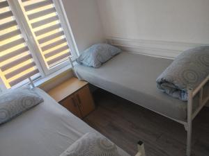 two beds in a small room with two windows at Apartment D&E in Sarajevo +2 photos