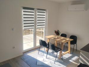 a dining room with a table and chairs and a window at Apartment D&E in Sarajevo