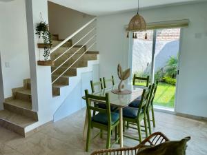 a dining room with a table and chairs and a staircase at Casa Boho - Heated Pool, Private Grill & Garden - Xochitepec in Tezoyuca