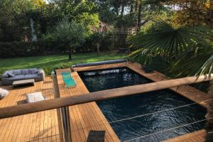 a swimming pool on a wooden deck in a yard at Cap Ferret Villa Océane in Lège-Cap-Ferret