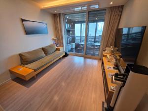a living room with a couch and a television at Farms Village in Jeju