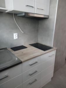 a kitchen with white cabinets and a counter top at Dominik in Bar