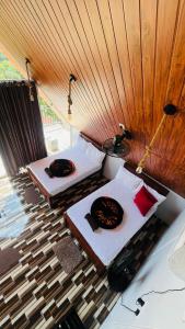 two beds in a room with a wooden ceiling at Dedunu Cabana & Resort in Badulla