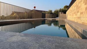 a pool of water next to a fence at Casa Giordana in Torri del Benaco