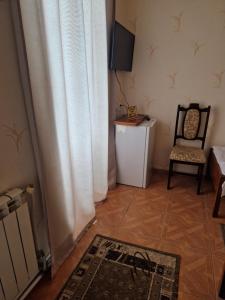 a living room with a television and a chair at DINA in Sisian