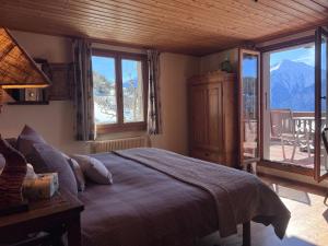 a bedroom with a bed with a view of a mountain at La Demeure des Elfes in Albinen