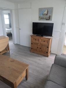 a living room with a flat screen tv on a wooden cabinet at The Bobbers in Great Yarmouth