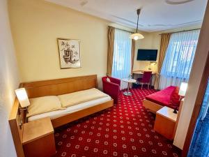 a hotel room with a bed and a red carpet at Hotel Restaurant Zum Hirschen in Donaueschingen