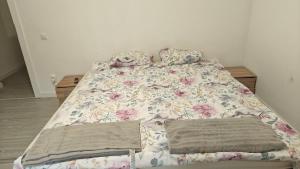 a bed with a floral comforter and two pillows at Ultracentral Biblioteca in Caracal