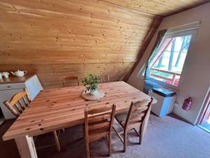 a wooden table with chairs and a potted plant on it at Domki Sosnówka-Kaszuby in Zgorzałe +17 photos
