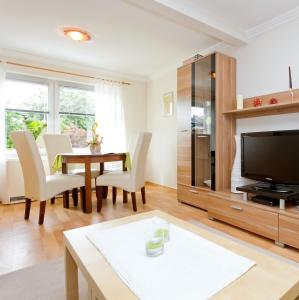 a living room with a table and a tv at Ferienwohnung Meeresbrise in Groß Kordshagen