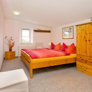 a bedroom with a large wooden bed with red pillows at Ferienwohnung Meeresbrise in Groß Kordshagen