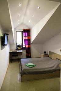 a bedroom with a bed and a desk and a window at Minihotel Freedom in Lviv