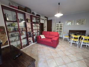 a living room with a red couch and a table at La Volpe e L'Iris in Campiano, Province of Verona