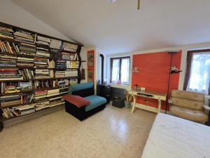 a living room with a chair and a desk and book shelves at La Volpe e L'Iris in Campiano, Province of Verona