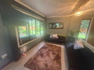 a living room with a couch and a rug at Dragon Fly in Stormsrivier