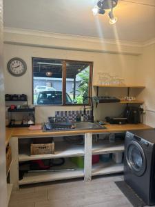 a kitchen with a desk with a sink and a window at Dragon Fly in Stormsrivier