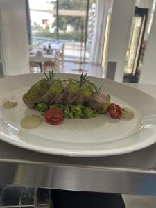 a white plate with meat and vegetables on a table at Polis Herb Garden in Polis Chrysochous +4 photos