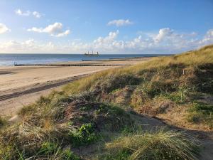 a beach with a boat in the water at Chalet B1 900m vom Strand in Koudekerke