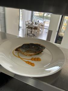 a fish on a white plate on a table at Polis Herb Garden in Polis Chrysochous