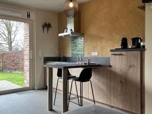eine Küche mit einem Tisch und zwei Hockern in der Unterkunft Bleekhoeve in Olen