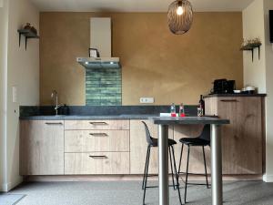 eine Küche mit Theke und einem Tisch mit Stühlen in der Unterkunft Bleekhoeve in Olen