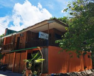 an orange building with a sign in front of it at RYJ's Inn in Siquijor