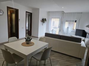 a living room with a couch and a table and chairs at Cannella Comfort Apartment in Bellagio