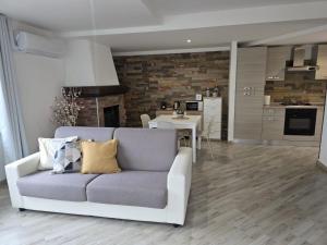 a living room with a couch and a kitchen at Cannella Comfort Apartment in Bellagio