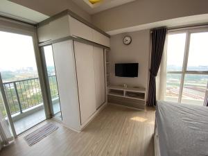 a bedroom with a bed and a tv and windows at Casa De Parco Apartment Max 4 Guests in Samporo