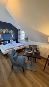 a bedroom with a bed and a chair and a table at Hotel Wuelfers Gasthaus in Groß Ippener +29 photos