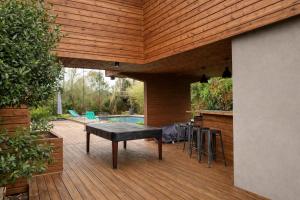 a patio with a table and chairs on a wooden deck at Cap Ferret Villa Océane in Lège-Cap-Ferret