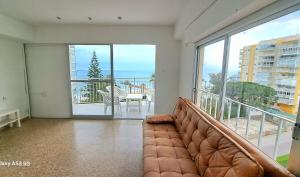 a living room with a couch in front of a large window at Frontal con vistas in Benicàssim