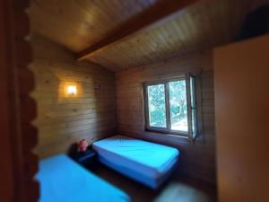 a small room with two beds and a window at chalets bois 150m de la plage in Olmeto