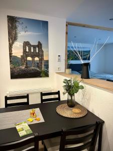 a dining room with a table and a painting on the wall at Fewo Catlen in Traben-Trarbach