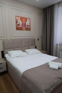 a bedroom with a large white bed with white pillows at Отель Кочевник in Astana