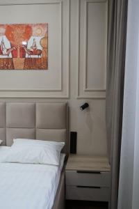 a bedroom with a bed and a painting on the wall at Отель Кочевник in Astana +7 photos