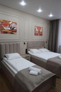 a bedroom with two beds with towels on them at Отель Кочевник in Astana