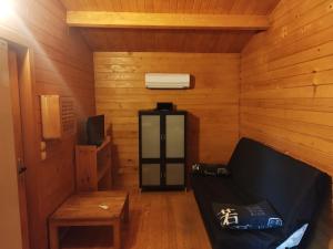 a room with a couch and a heater in a cabin at chalets bois 150m de la plage in Olmeto