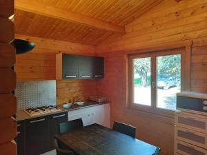a kitchen with a table and a window in a cabin at chalets bois 150m de la plage in Olmeto