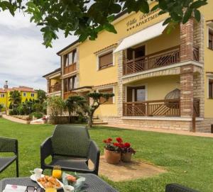 a table and chairs in front of a building at Apartments Bellissima in Funtana