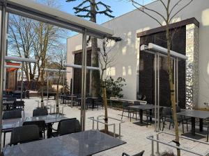 a patio with tables and chairs and a building at Hotel Marton in Koszalin