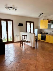a kitchen with yellow cabinets and a table and a chair at Aura LT - Vicinissima all'aeroporto in Fiumicino