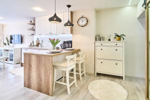 a kitchen with white cabinets and a table and chairs at Smart apartmány Prešov in Prešov